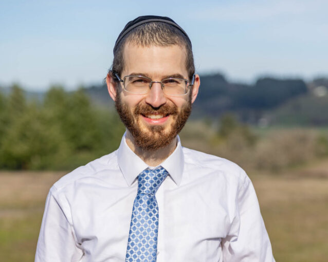 Smiling man with glasses wearing tie outdoors
