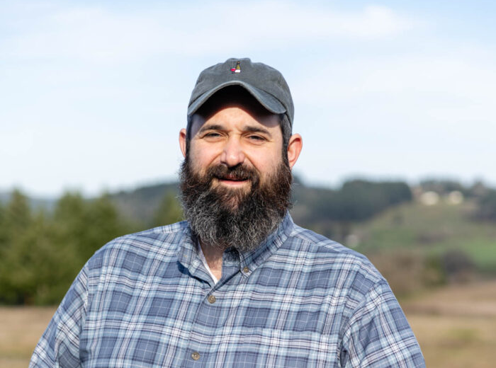 Smiling bearded man in cap outdoors