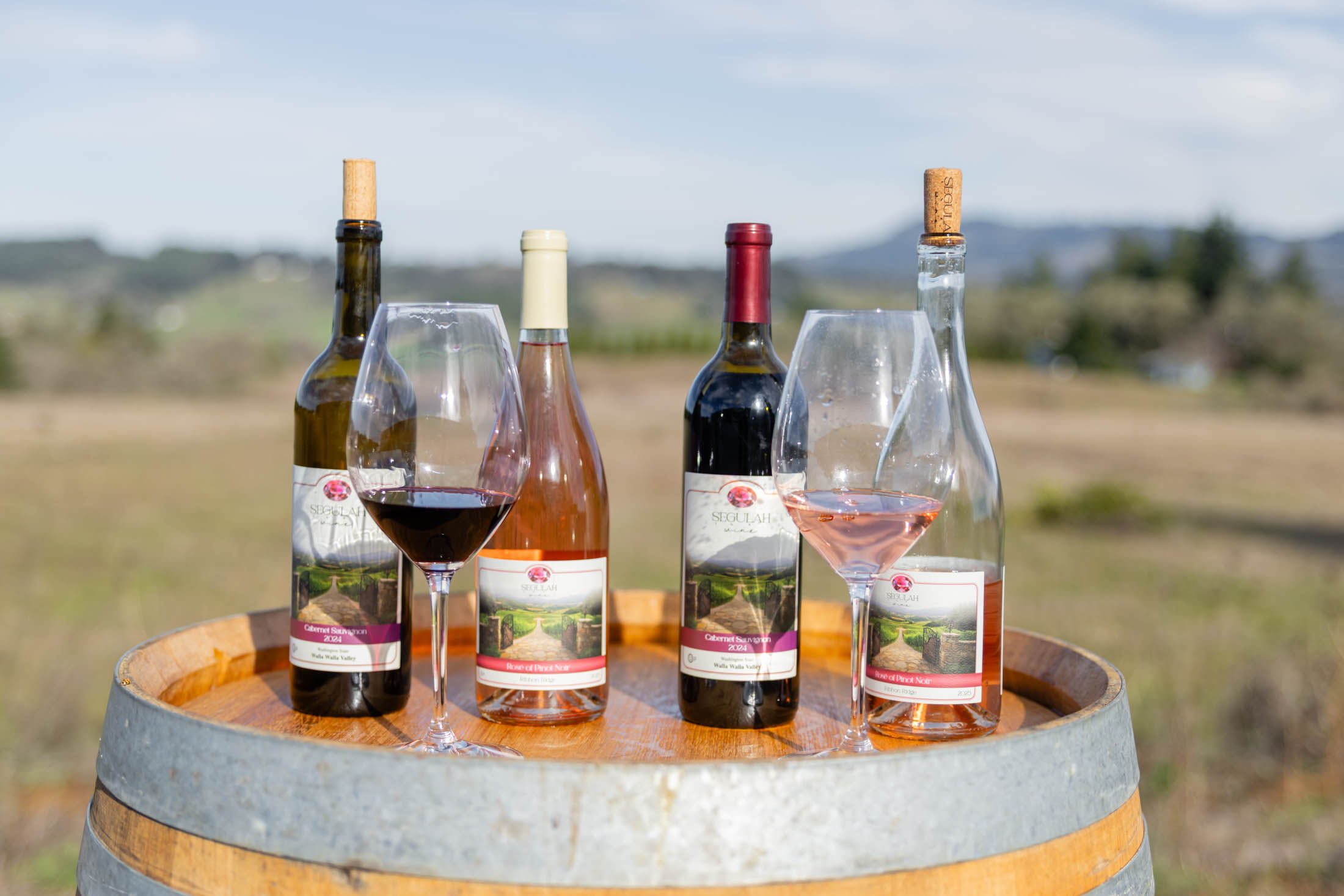 Wine bottles and glasses on wooden barrel